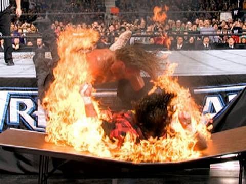 Edge spears Foley through a fire table