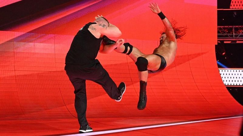 Drew McIntyre laying Lesnar down with consecutive Claymore Kicks