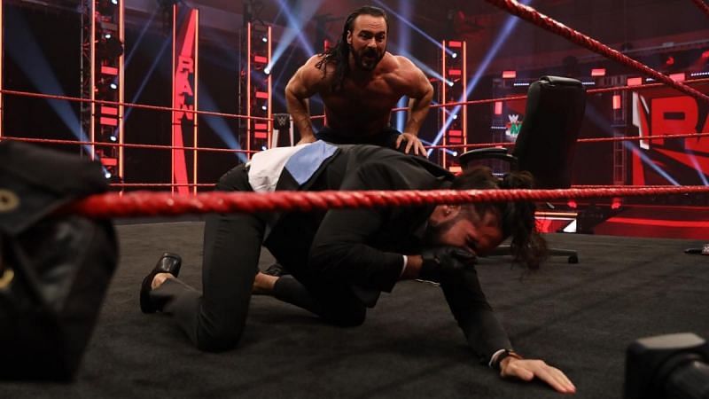 Drew McIntyre taunting Seth Rollins after signing the contract for their match