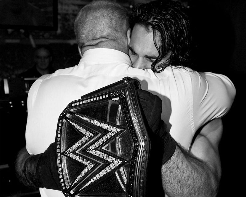 Seth Rollins and Triple H share a hug.