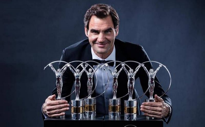 Roger Federer poses with his record six Laureus trophies