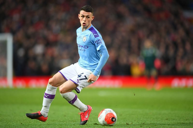 Phil Foden dribbling with the ball in recent Manchester Derby