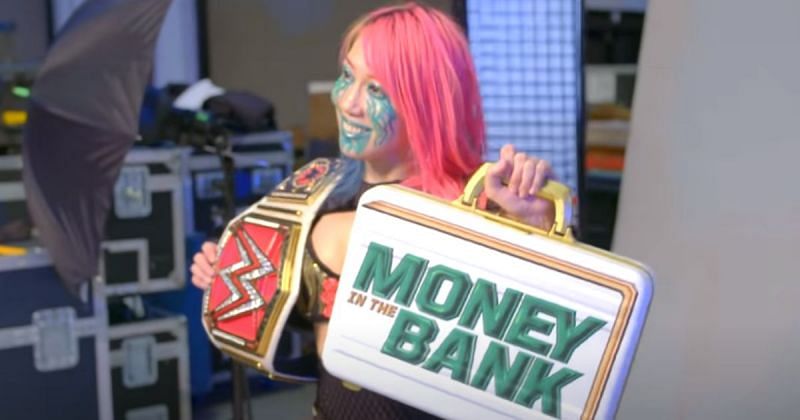 Asuka posing with the RAW Women&#039;s title and the MITB briefcase.