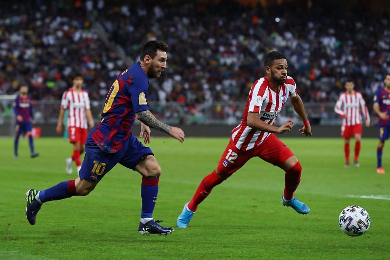Lionel Messi attempts to win the ball in a duel with Renan Lodi