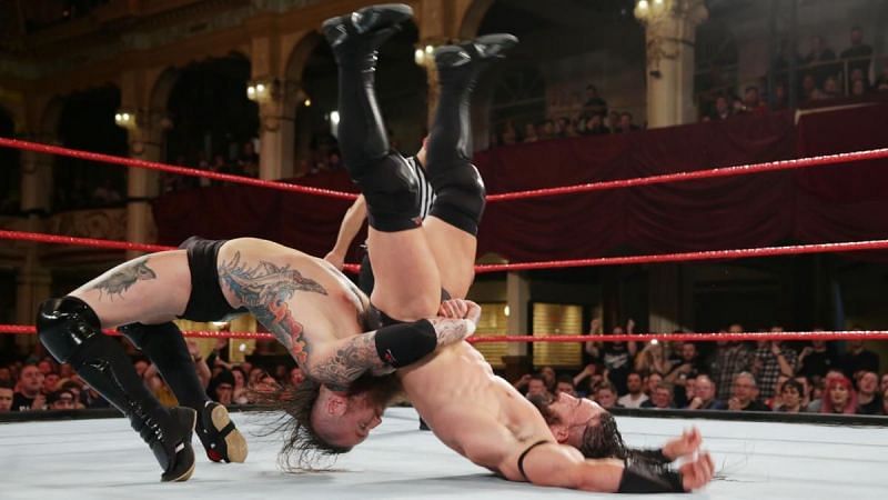 Aleister Black hitting Neville with a German Suplex.