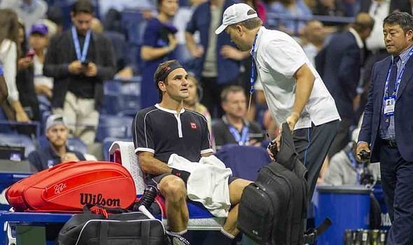 Roger Federer receives back treatment during his quarterfinal match at the 2019 US Open