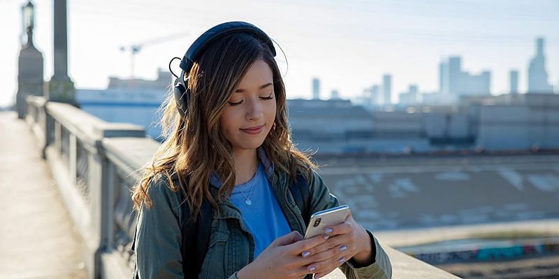 Pokimane smiles while looking at her phone