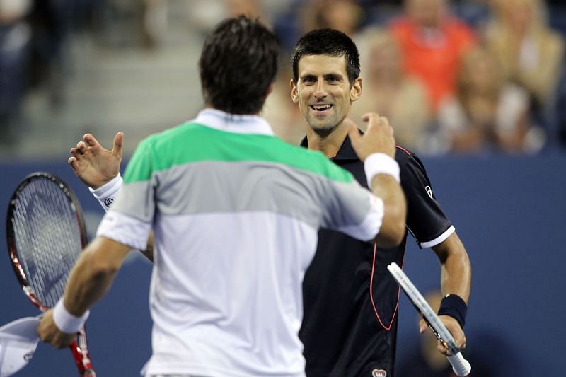 Novak Djokovic (R) shakes hands with Carlos Berlocq after defeating him