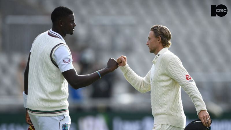 Jason Holder (L) and Joe Root exchange a fist bump during the second Test