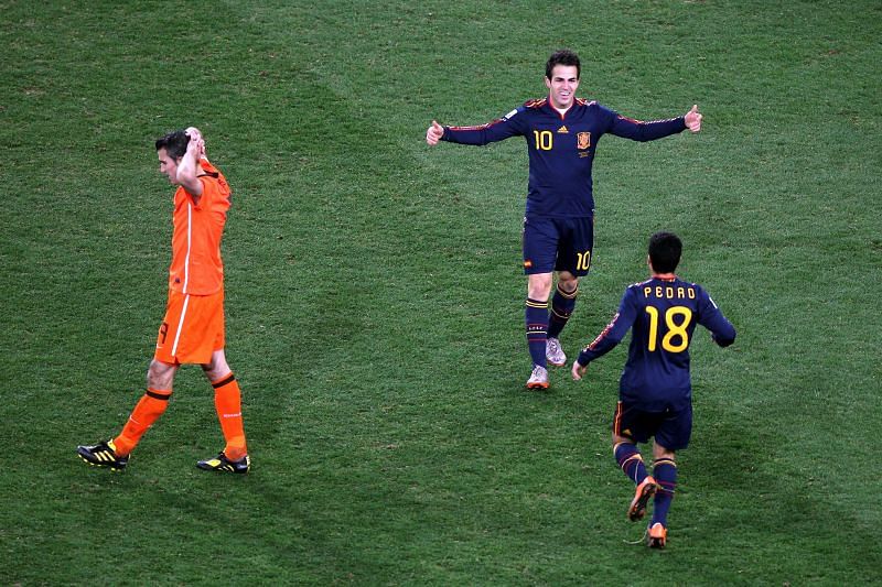 Cesc Fabregas and Pedro celebrate after winning the 2010 World Cup behind a distraught Robin Van Persie
