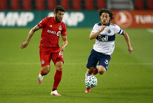 Alejandro Pozuelo of Toronto FC battles for the ball with Russell Teibert of Vancouver 