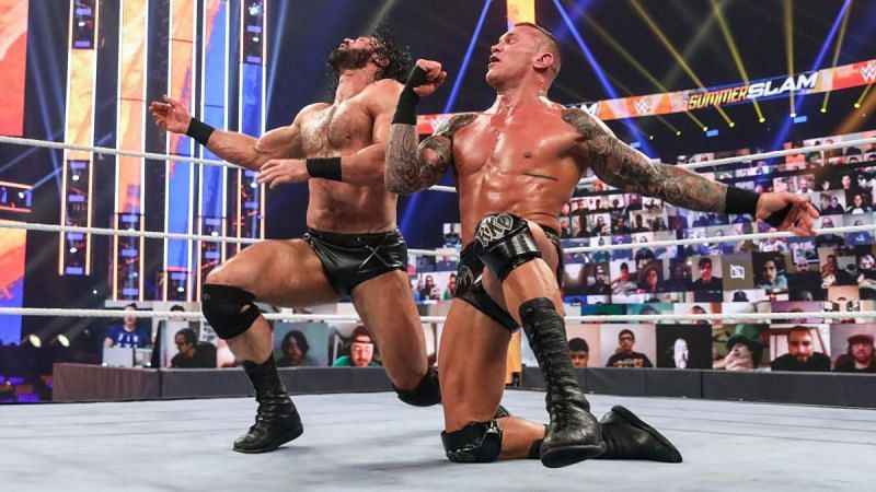 Randy Orton hitting Drew McIntyre with a fist.