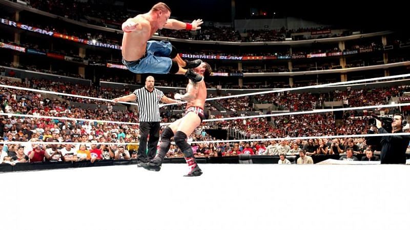 Cena hitting Punk with a dropkick as an impassive Triple H watches in the corner