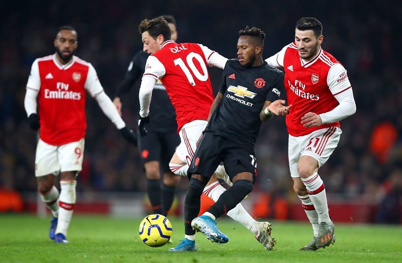 Manchester United midfielder Fred stealing the ball off Mesut Ozil