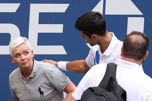 Novak Djokovic tends to the line judge