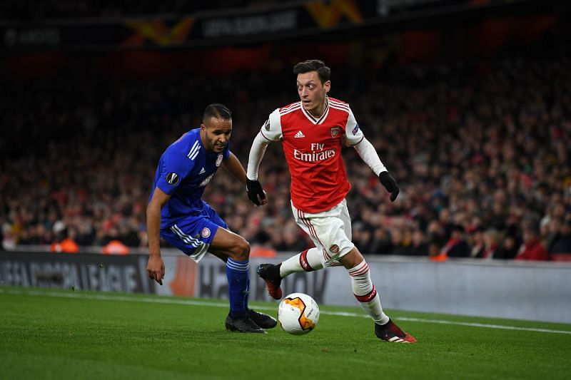 Arsenal&#039;s Mesut Ozil is challenged by Youssef El Arabi.