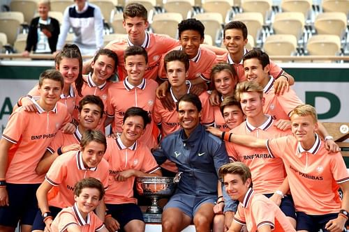 Rafael Nadal celebrates victory with the ball boys following his 2019 French Open title