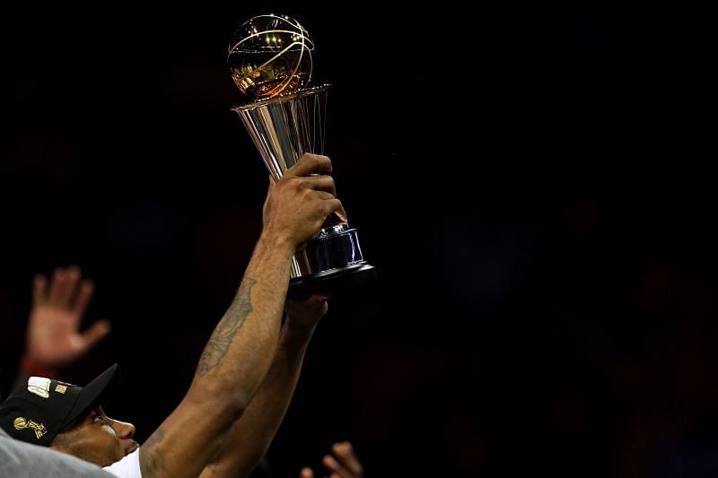 Kawhi Leonard holding the Bill Russell NBA Finals MVP award in 2019.