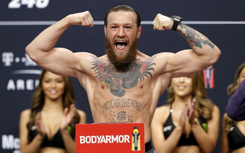 Conor McGregor poses on the scale