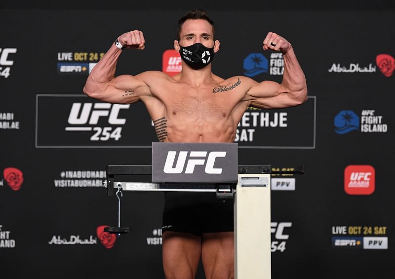 Michael Chandler poses on the scale during the UFC 254