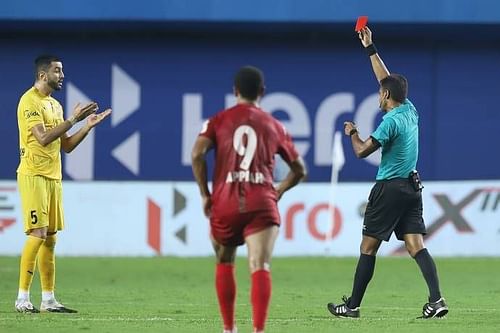 Ahmed Jahouh (in yellow) being shown the red card in the game between MCFC & NEUFC