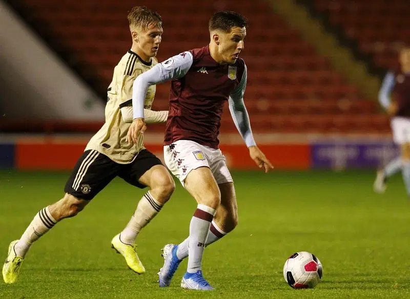 Michael Tait of Aston Villa runs with the ball under pressure from Ethan Galbraith of Man United