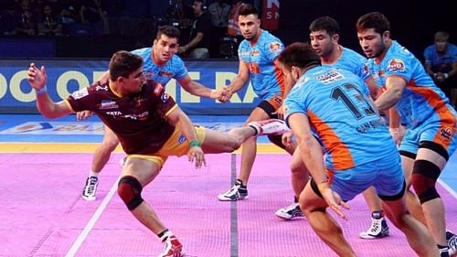 Maninder Singh (in chain with Surjeet Singh) looks on as Nitin Tomar attempts a kick