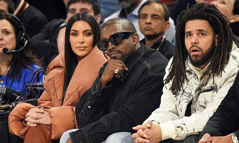 Kim Kardashian, Kanye West and J Cole (from left to right) sitting courtside in an NBA game