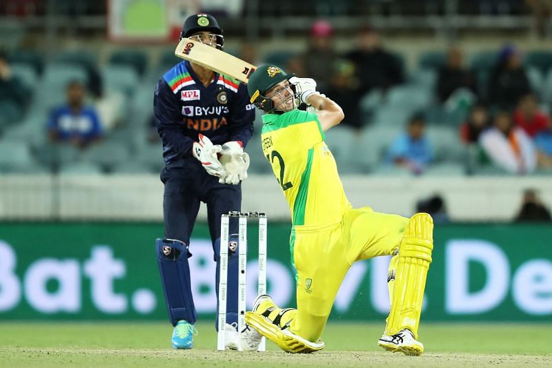 Cameron Green plays a lofted shot as KL Rahul looks on from behind the stumps 