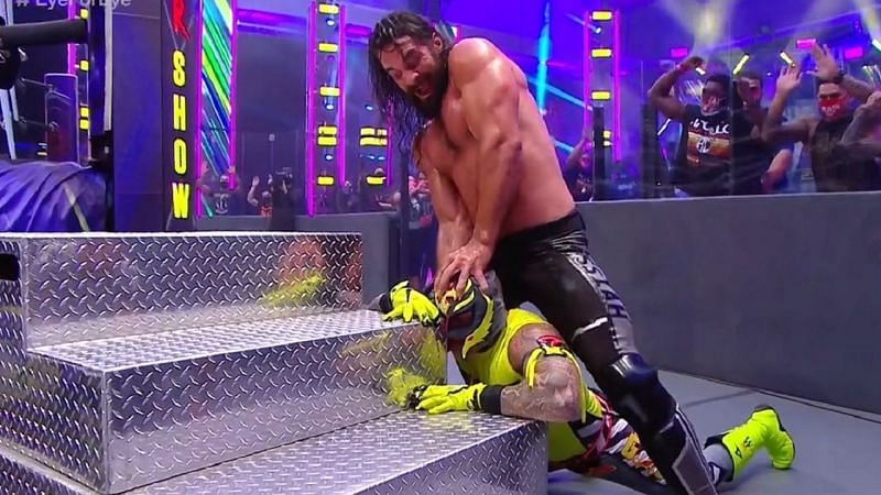 Seth Rollins inflicting punishment on Rey Mysterio