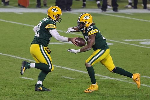 Aaron Rodgers hands the ball off to Aaron Jones