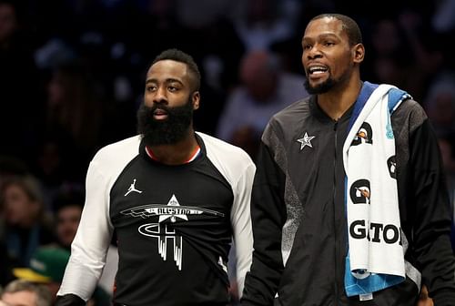 James Harden and teammate Kevin Durant watch on from the bench during the NBA All-Star game 