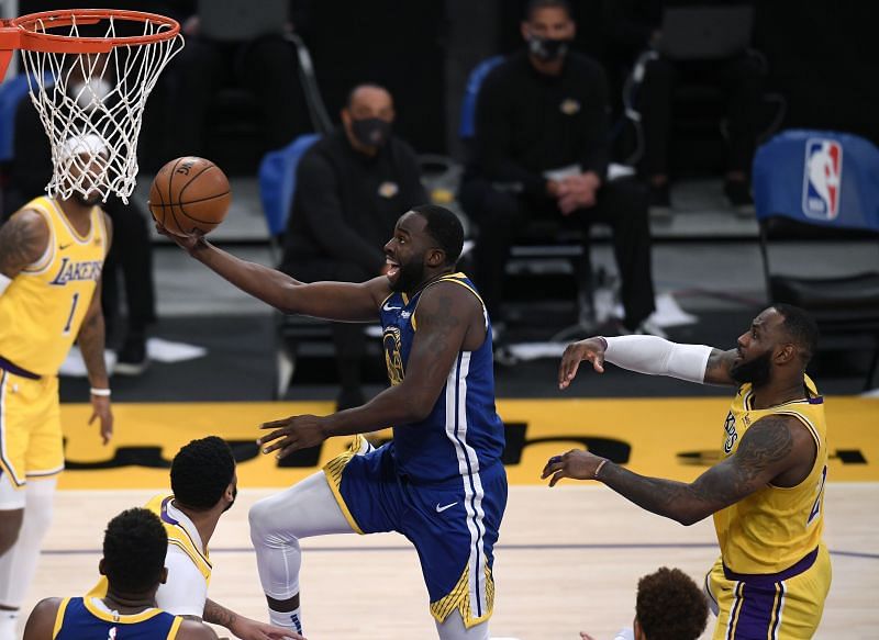 Draymond Green #23 of the Golden State Warriors scores on a layup past LeBron James #23 of the Los Angeles Lakers