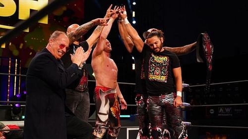 Kenny Omega with Don Callis, The Young Bucks, and The Good Brothers.