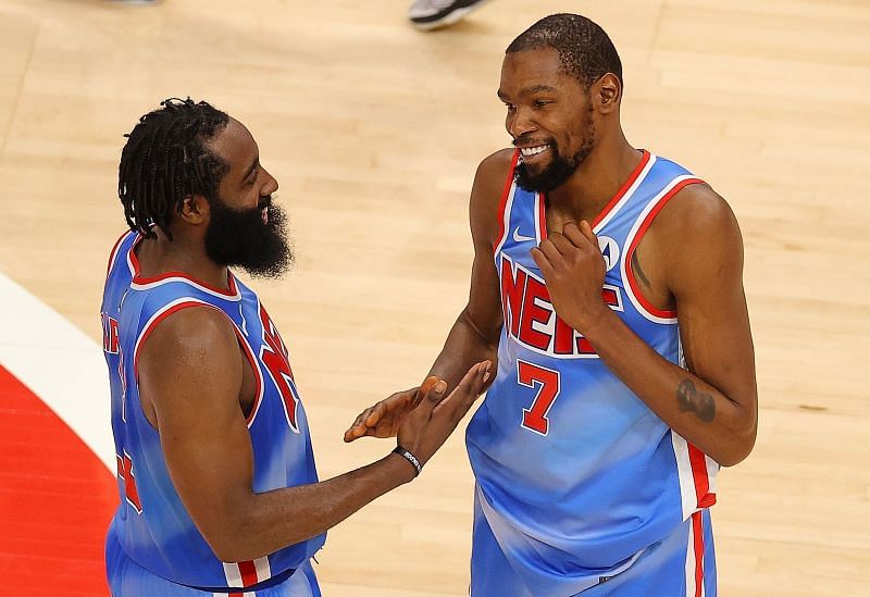 Kevin Durant #7 and James Harden #13 of the Brooklyn Nets celebrate their 132-128 overtime win