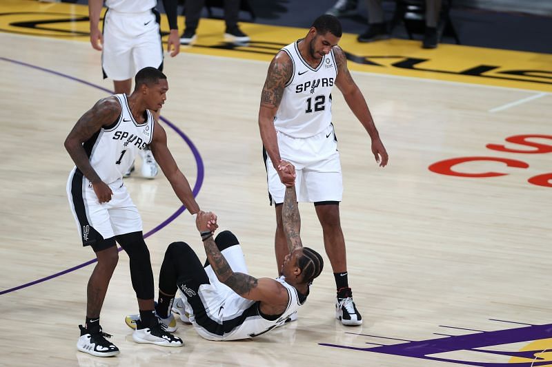 DeMar DeRozan #10 is picked up off the court by LaMarcus Aldridge #12 and Lonnie Walker IV #1 of the San Antonio Spurs during a game against the Los Angeles Lakers at Staples Center on January 07, 2021 (Photo by Sean M. Haffey/Getty Images)