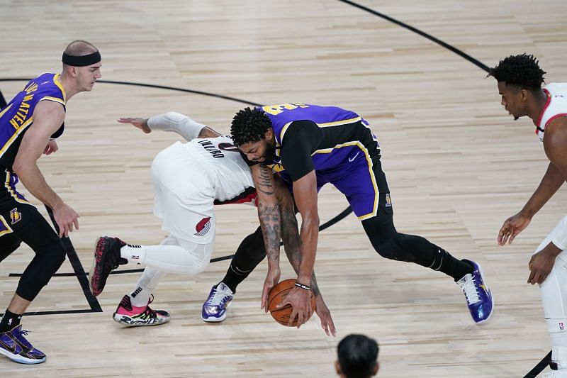 Anthony Davis #3 of the Los Angeles Lakers and Damian Lillard #0 of the Portland Trail Blazers scramble for a loose ball (Photo by Ashley Landis-Pool/Getty Images)