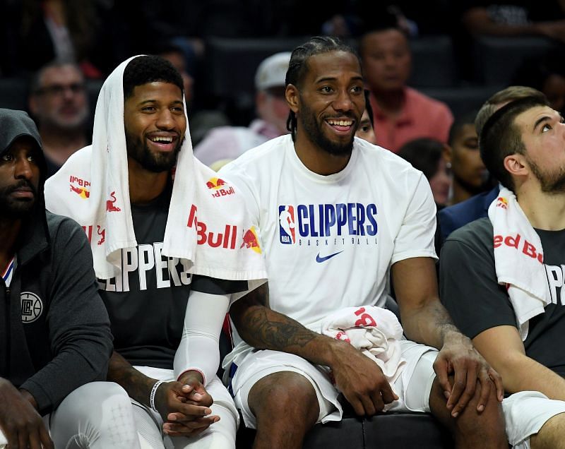 Paul George and Kawhi Leonard share a light moment on the bench.