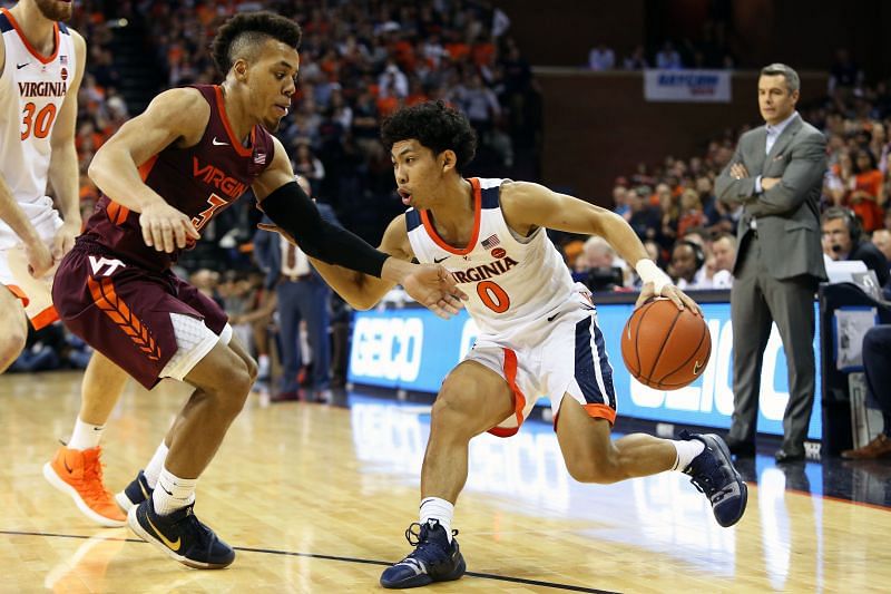 Kihei Clark #0 of the Virginia Cavaliers drives past Wabissa Bede #3 of the Virginia Tech Hokie