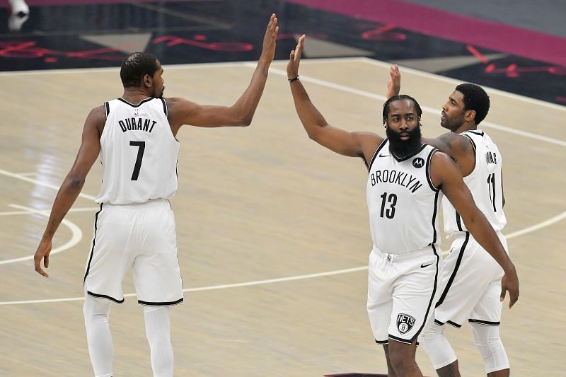  Kevin Durant #7 James Harden #13 and Kyrie Irving #11 of the Brooklyn Nets celebrate during the first quarter against the Cleveland Cavaliers at Rocket Mortgage Fieldhouse on January 20, 2021 in Cleveland, Ohio (Photo by Jason Miller/Getty Images)