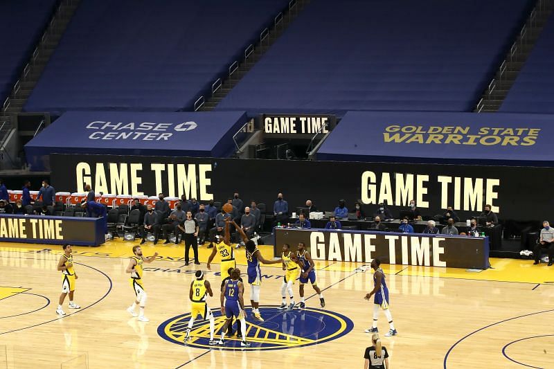 Myles Turner of the Indiana Pacers and James Wiseman of the Golden State Warriors jump for the ball at the start of their game 