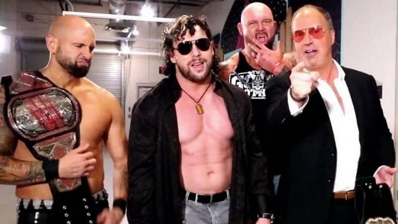 Kenny Omega with Don Callis and The Good Brothers.