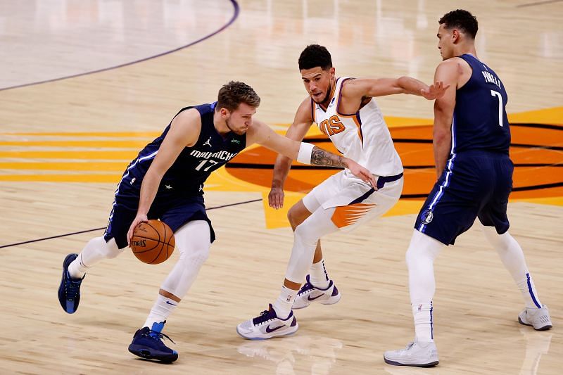 Luka Doncic of the Dallas Mavericks drives the ball against Devin Booker of the Phoenix Suns during the NBA game at PHX Arena on December 23, 2020