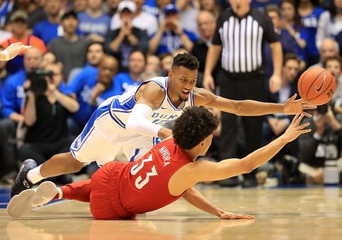 Javin DeLaurier #12 of the Duke Blue Devils dives after a loose ball against Jordan Nwora #33 of the Louisville Cardinals