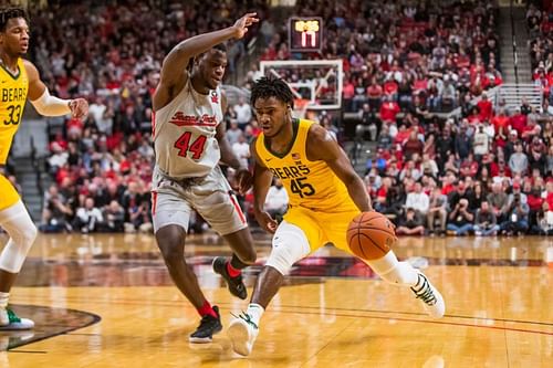 Davion Mitchell #45 of the Baylor Bears drives against Chris Clarke #44 of the Texas Tech Red Raiders