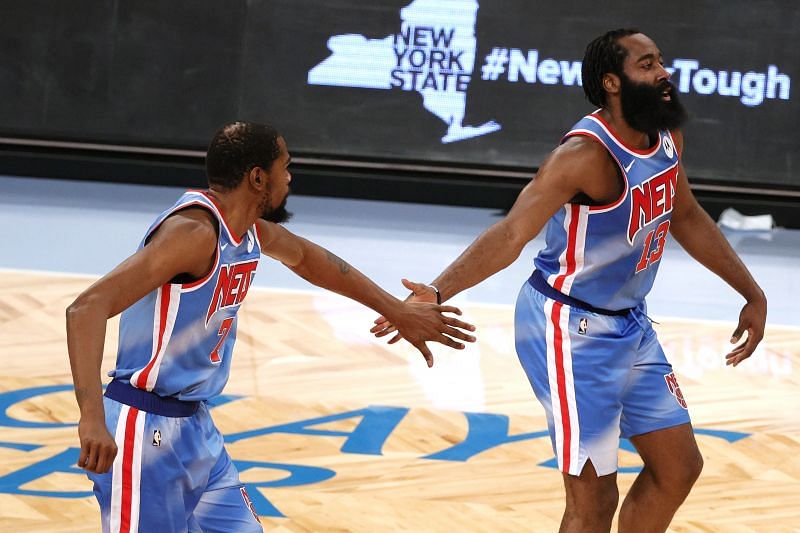 Kevin Durant high-fives James Harden of the Brooklyn Nets during a game against the Orlando Magic