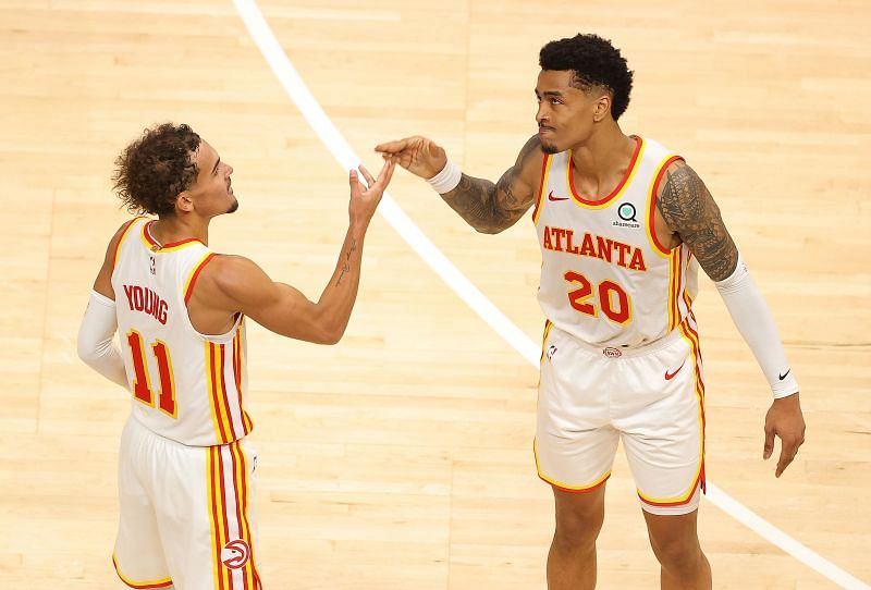 Trae Young #11 and John Collins #20 of the Atlanta Hawks celebrate their 123-115 overtime win over the Detroit Pistons at State Farm Arena on January 20, 2021 in Atlanta, Georgia. (Photo by Kevin C. Cox/Getty Images)