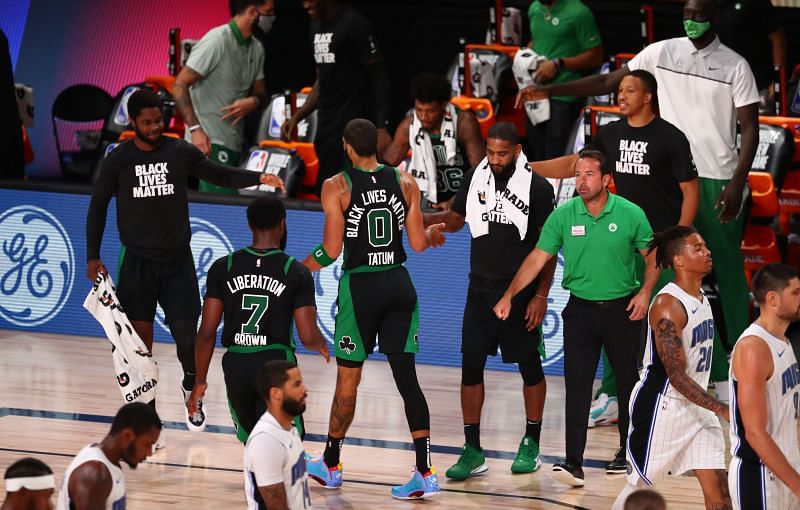 Jayson Tatum greets the Boston Celtics bench during their game with the Orlando Magic.