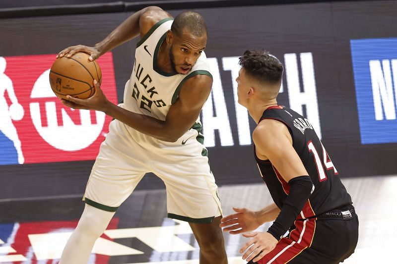 Khris Middleton #22 of the Milwaukee Bucks is defended by Tyler Herro #14 of the Miami Heat.
