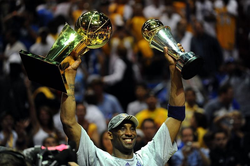 Kobe Bryant #24 of the Los Angeles Lakers holds up the Larry O&#039;Brien trophy and the Bill Russell MVP trophy.